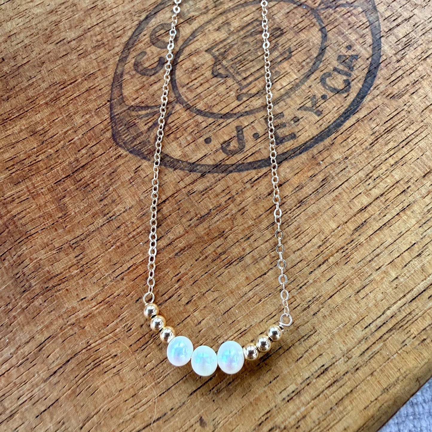 Three pearl necklace with small beads on a wooden surface