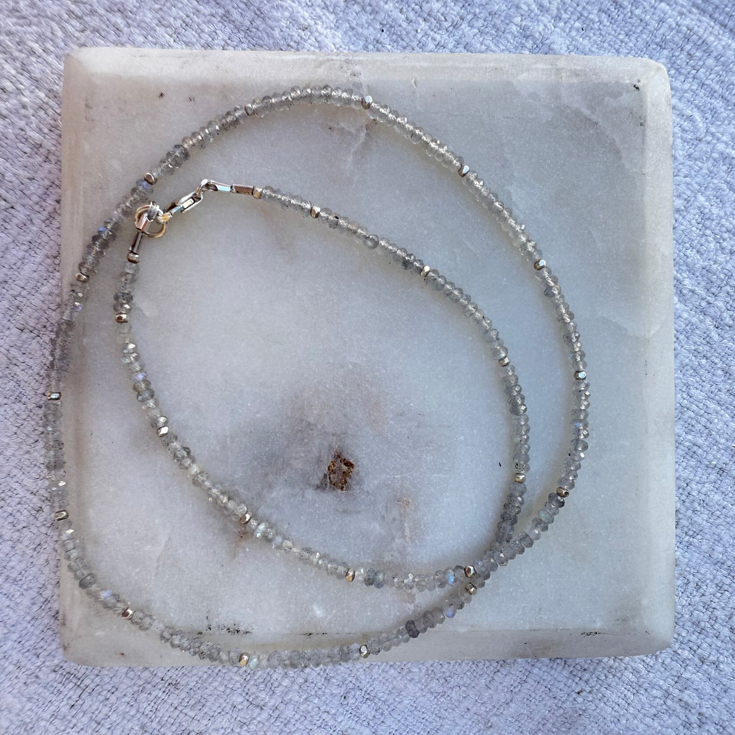 Beaded labradorite necklace on a marble surface