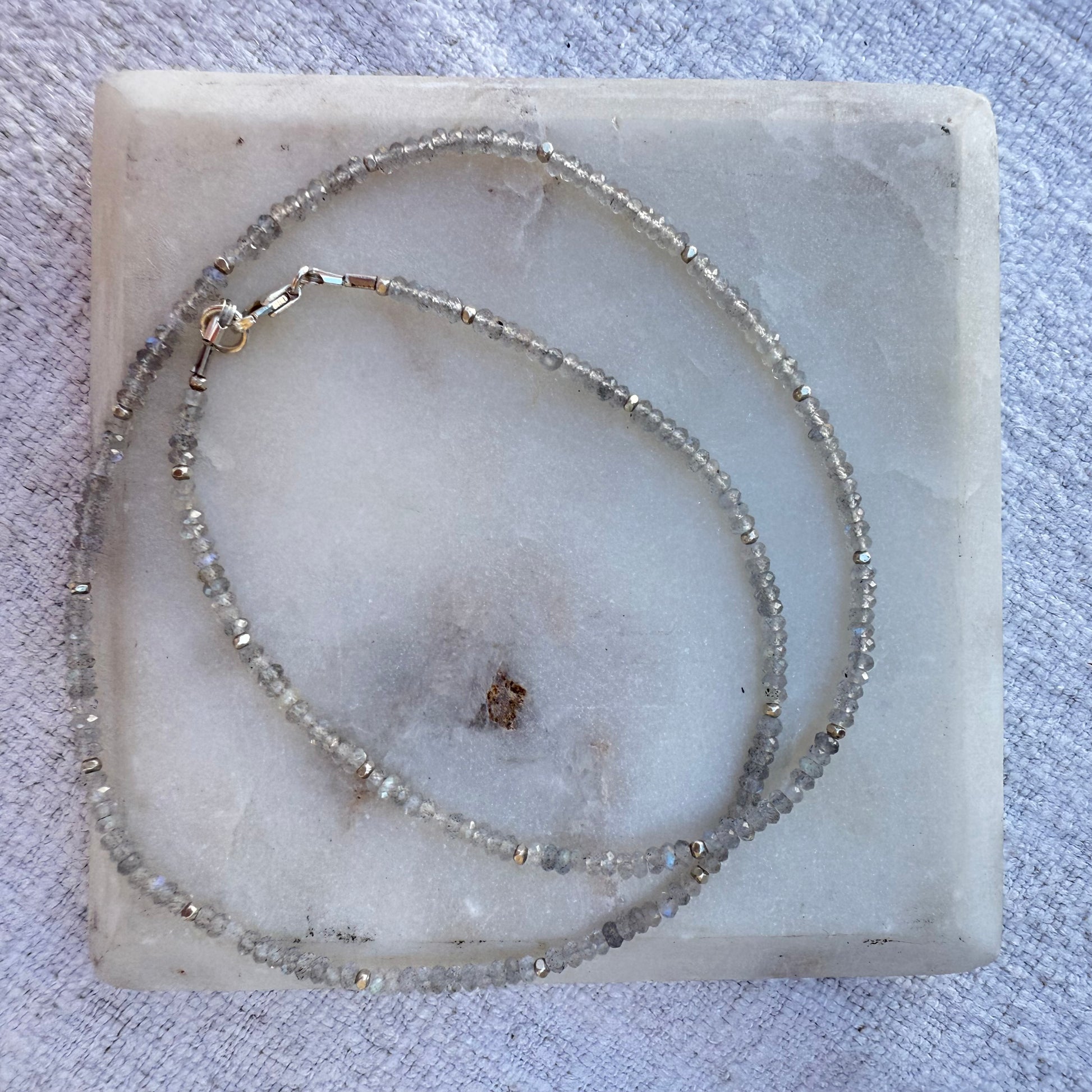 Beaded labradorite necklace on a marble surface