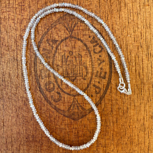 Labradorite necklace on a wooden cigar box with logo